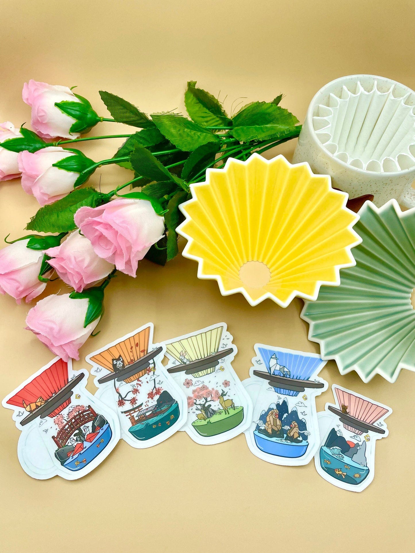 five stickers with different colored origami drippers and mini world scenes in the carafes